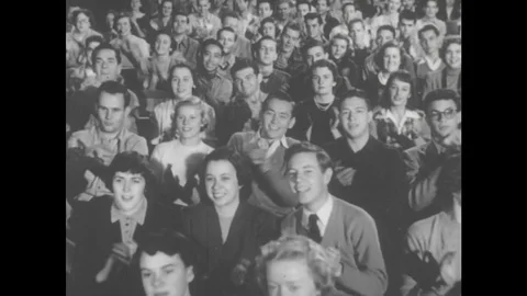 1950s: UNITED STATES: audience applauds. Musician speaks to audience in theatre. Stock Footage
