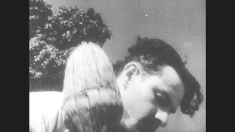 1950s: United States: Man Bangs Ground With Stick. Windmill Sails Spin. Men Hit Stock Footage 80688183
