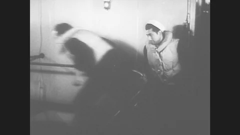 1950s: UNITED STATES: sailors in life jackets run up steps. Sailors grab life Stock Footage
