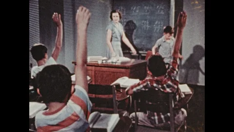 1950s: UNITED STATES: students raise hands in class. Teacher at Boystown school. Stock Footage