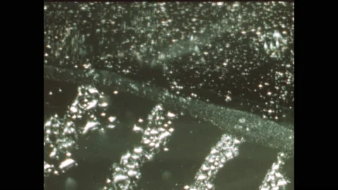 1950s: View through microscope.  Young man stands up and speaks to doctor. Stock Footage 140150511