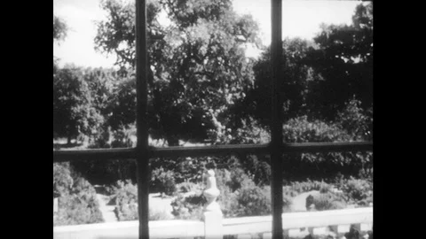 1950s: View of trees through a window. A farmhouse stands in the snow among bare Video stock 83825428