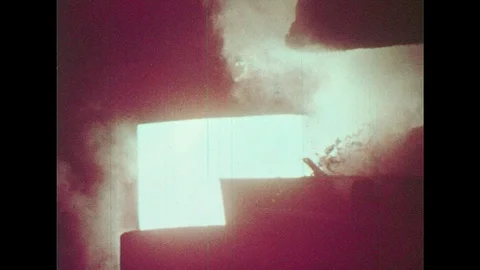 1950s: White hot metal pushed into furnace. Man skiing down mountain. Man with Stock Footage