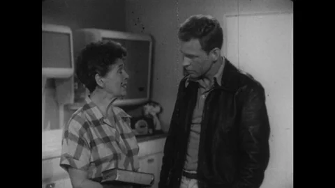 1950s: Woman with Bible talks to young man in kitchen. Young man listening, Stock Footage