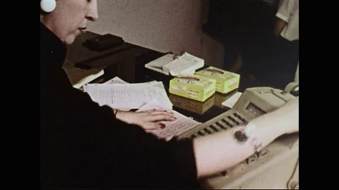 1950s: Woman uses adding machine / Man and boy in office. Stock Footage 74570548