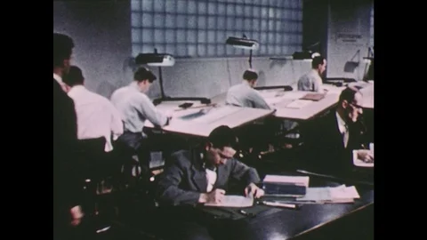 1950s: workers in engineering department. Men work at boards. Man walks through Video stock 74816031