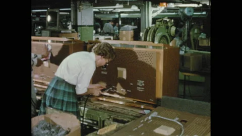 1950s: Workers use power sockets to attach backs to television sets on assembly Stock Footage 155113929