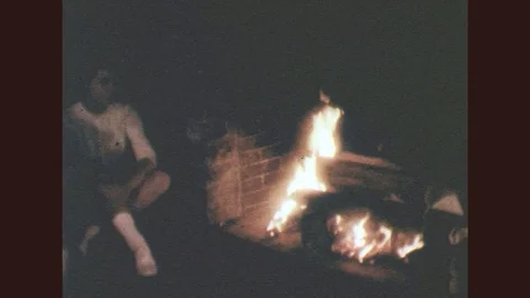 1950s: Young people sit around fire Stock Footage
