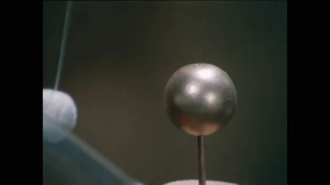1950s:Pith ball repulsed from brass ball. Pith ball attracts to brass ball. Film Video stock 229570679
