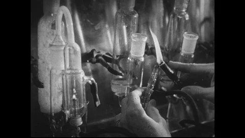 1950s:Scientist working in laboratory with glass test tubes and Bunsen burner. Stock Footage 74425449