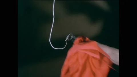 1950s:String attached to tube. Hand uses cloth to wipe tube. Hand follows string Stock Footage 229570818