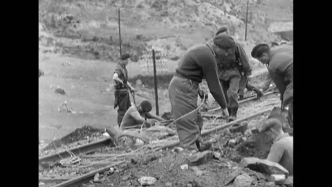 1951- Commandos dig under railroad tracks; a group of Native people are shown Stock Footage 228942578