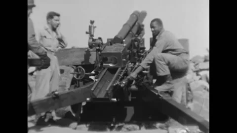 1951 - Gun crew are loading and firing a howitzer. Two members clean the bore. Stock Footage 232892622