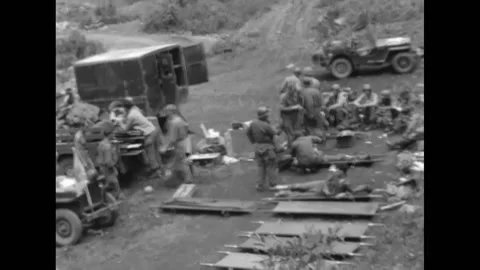 1951 - A US Army chaplain helps army doctors load wounded men onto ambulances in Video stock 168931928