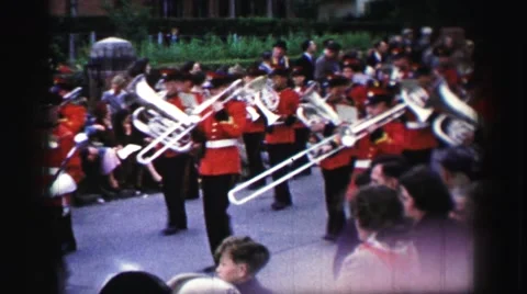 1952: People Watching a Parade Progress by with Marching Band and Horse-Drawn Stockbeeldmateriaal 67480480