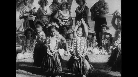 1952 : Three girls hula dance as music plays and people partake in a luau. Stock Footage