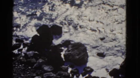 1952: the white frothy sea kissing the black rocky shore INTERNATIONAL WATERS Stock Footage