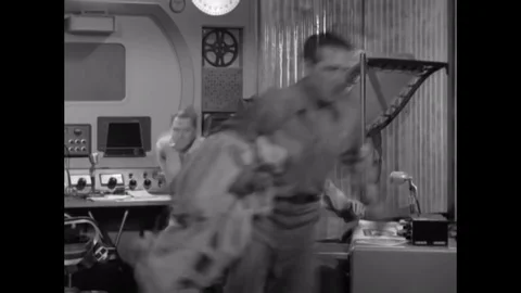 1953 - With help from two of his colleagues, an astronaut suits up with heavy Vidéo 129449838