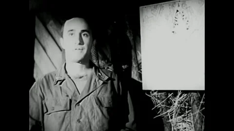 1953 - A lieutenant goes over an attack plan with soldiers, pointing to a map Stock Footage