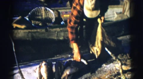 1953: the man puts fishes into the thread bag WISCONSIN Stock Footage