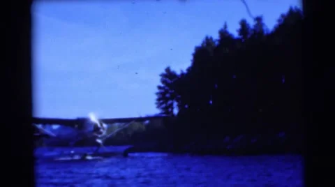 1953: seaplane drifts along blue river near shore WISCONSIN Stock Footage
