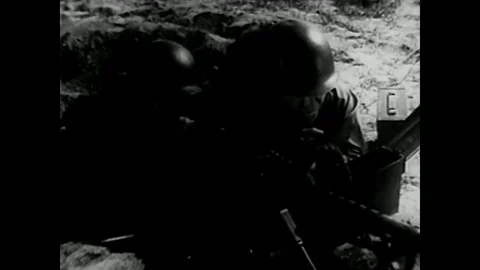 1953 - Squads fire weapons, including a bazooka, into a town and enemy soldiers Stock Footage 79431018