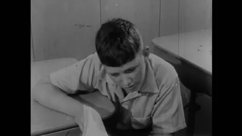 1954 - A boy develops photographs in a dark room before going out to meet his 動画素材 164593391