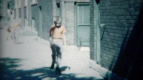 1954: Boys in Orange Practicing Rollerskating on Chicago City Streets Stock Footage 58138195