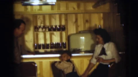 1954: a small boy climbing up on a bar stool as his parent look on PENNINGTON, Stock Footage