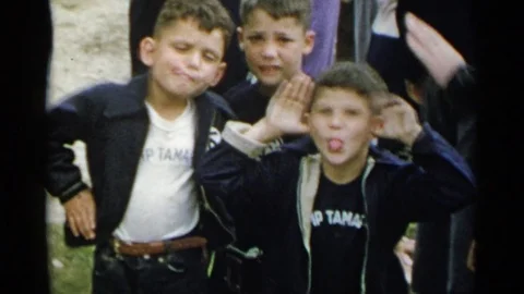 1954: Three Young Boys Stand in Front of a Crowd Making Faces Stock Footage 73158503