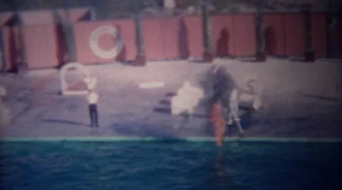1955: Trained Dolphin Jumping Through Flaming Hoop of Fire in Pool Stock Footage 60331392