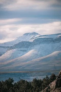 A beautiful landscape view of trees under snow cliffs against a gray sky in Matroosberg, South Africa xkwx abstract, background, beautiful, beauty, blue, cloud, clouds, geology, hill, landscape, Matroosberg, natural, nature, outdoor, outdoors, rock, scenic, sky, snow, South Africa, stone, sunny, texture, travel, tree, trees, vertical, view, water, white, winter