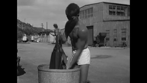 1957 - A US Navy diver washes his flippers and Aqua-Lung regulator. Stock Footage 120937123