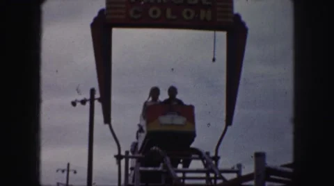 1958: children and adults sit on a mild roller coaster ride going over a hill. Stock Footage