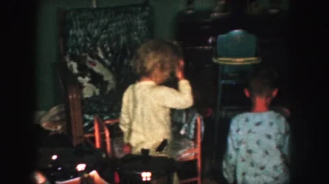 1958: children in pajamas examining their christmas gifts under the tree AMES Stock Footage