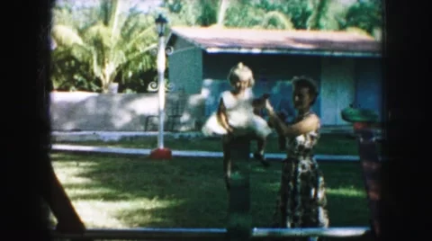 1958: children playing on seesaw with mother in a local park AMES, IOWA Stock Footage