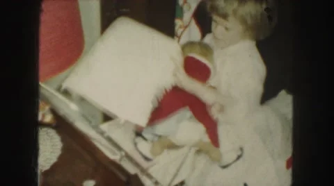 1958: the funny girl in white frock putting her doll in the trolley AMES, IOWA Stock Footage
