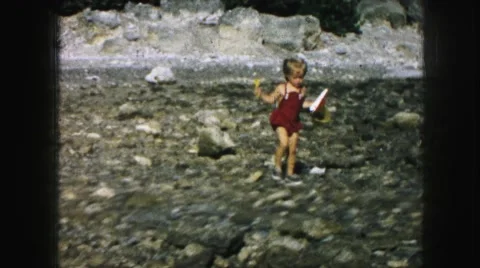 1958: small cute kid is walking with a bucket through a rough ground AMES, IOWA Stock Footage