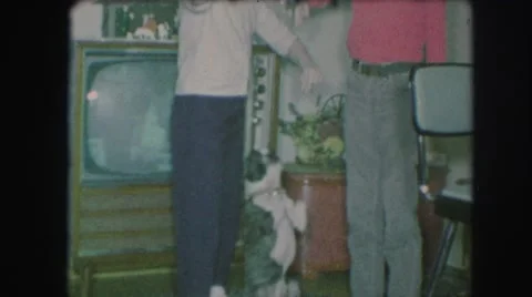 1958: three people playing with a dog at christmas time. AMES, IOWA Stock Footage