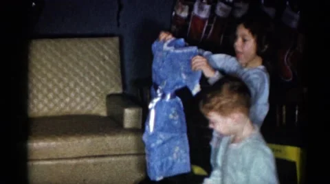 1959: children unwrapping their presents on christmas morning CATSKILL GAME Stock Footage