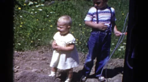 1959: two adorable children standing outside in a dirt patch CATSKILL GAME FARM Stock Footage