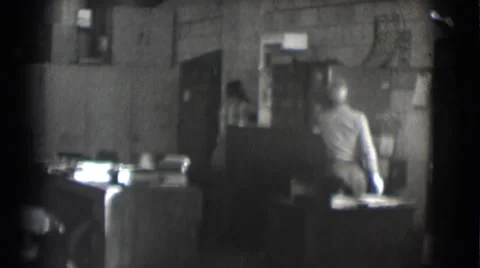 1959: Two Men Performing Tasks in a Cluttered Office with Cabinets in St. Louis Stock Footage 67580294