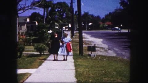 1960: daughter walking elderly grandmother down sidewalk street FLORIDA Stock Footage