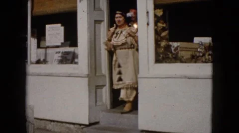 1960: two red indian women dancing in street while a third woman passes by Stock Footage