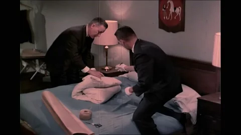 1960s: Agents in gloves use marker to put date 3/15/67/ BMS/RFA on bedding. Stock Footage 163825799