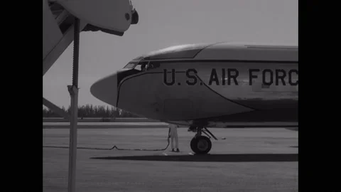 1960s: Air force base.  Man directs plane into position.  Men push ladder to 스톡 동영상 150341678