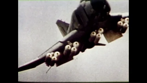 1960s: Airplane drops bombs.  Explosions on ground. Video stock 128192087