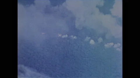 1960s: American planes carpet bomb Vietnam countryside. Navy guns shooting from Stock Footage