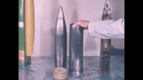 1960s: Ammunition on table, hand points, puts bag into empty shell. 스톡 동영상 247157783