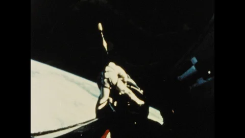 1960s: Astronaut in space suit performs spacewalk on Gemini craft. Gemini 12 Stock Footage 101665693